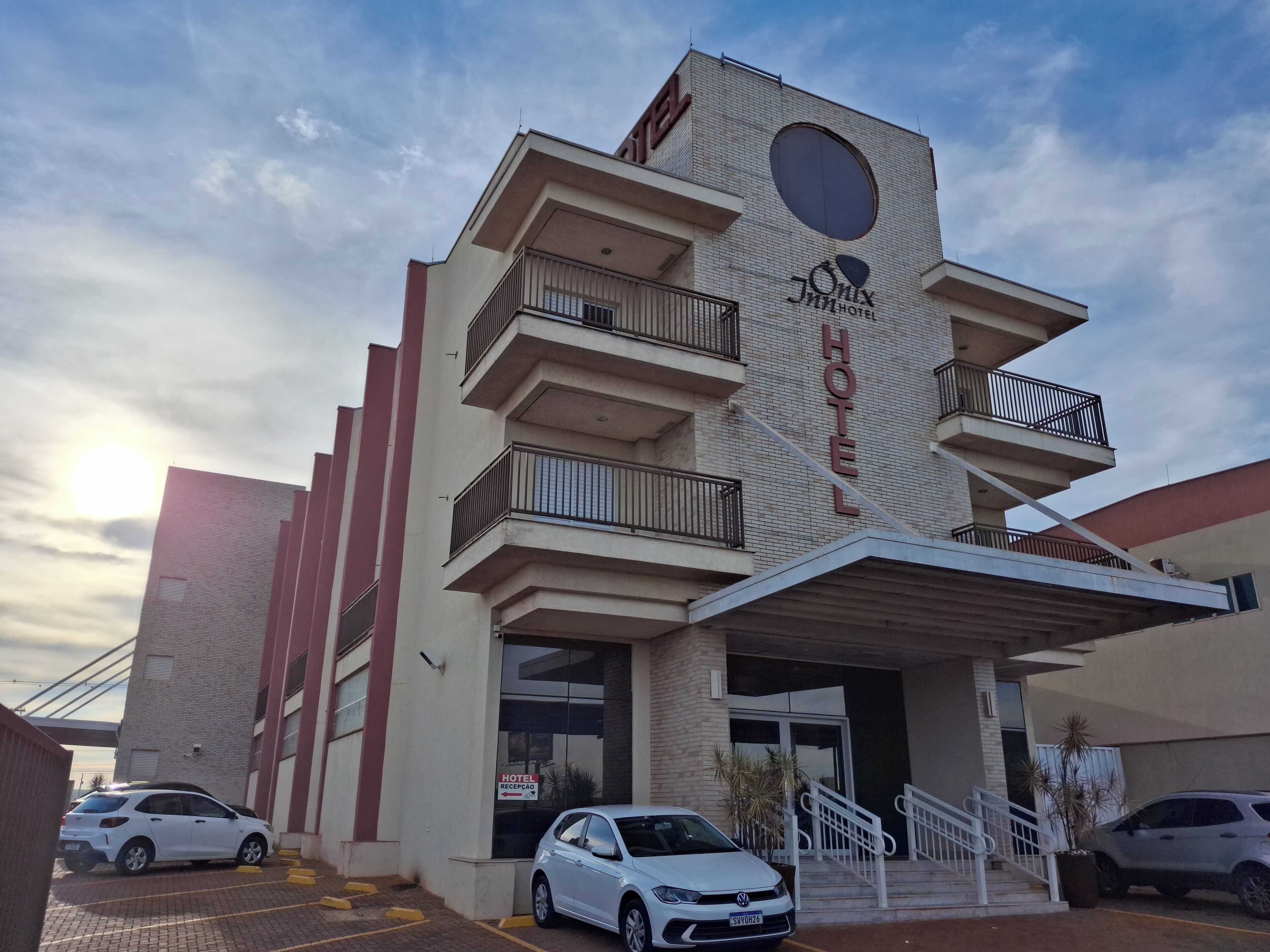 A hotel with a modern design, featuring multiple balconies and a prominent entrance.