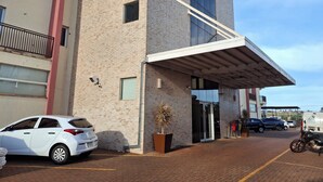 A modern building with a brick facade, large windows, and a covered entrance. - Onix Inn Hotel Cravinhos (Cravinhos)