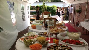 A buffet table with various dishes and a wine bottle. - Hotel Ammerländer Hof (Westerstede)