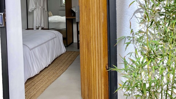 A bedroom with a bed, a wardrobe, a mirror, and a plant. - Casa Figa 39 (Zagreb)