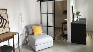 A modern living room with a grey sofa, a wooden side table, and a black console. - Casa Figa 39 (Zagreb)