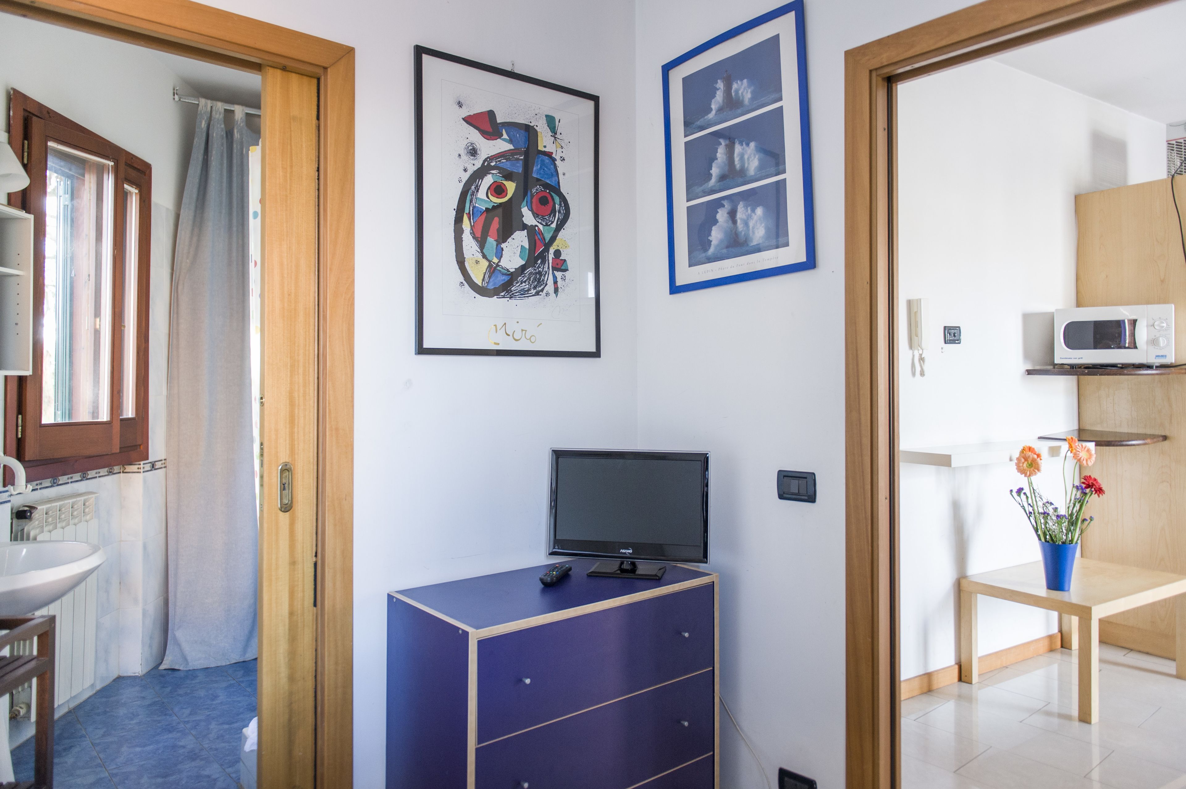 Un espace de vie compact comprenant une salle de bain, un coin cuisine et un espace repas.