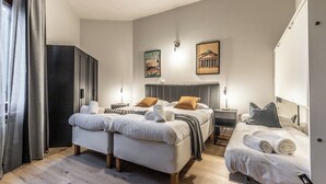 A modern bedroom with two beds, a wardrobe, and artwork on the walls. - Flatinrome Trastevere (Rome)