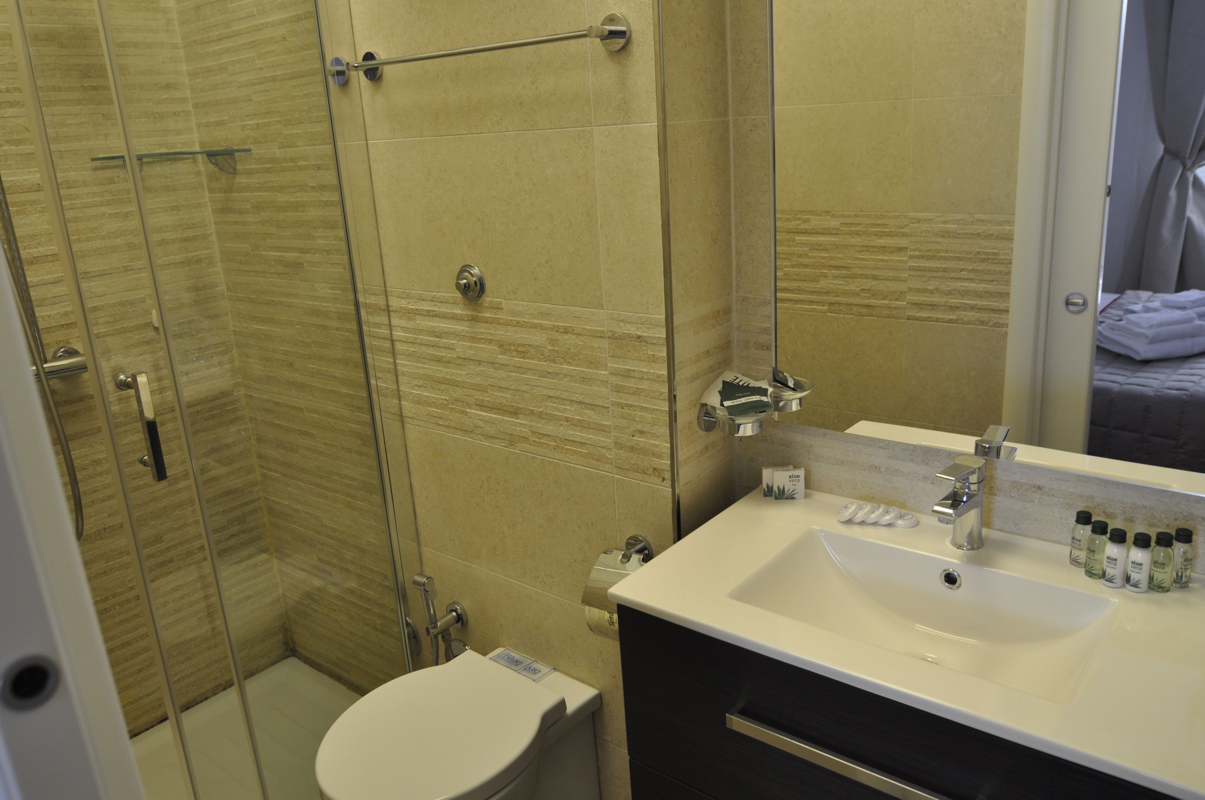 Un baño moderno con cabina de ducha de vidrio, un lavabo blanco y un espejo.