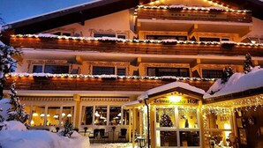 A multi-story hotel with a traditional Alpine architectural style, featuring balconies and a snow-covered roof. - Ferienhotel Schwarzwälder Hof (Feldberg)