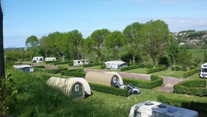 A campsite with multiple RVs and caravans, surrounded by well-maintained hedges and trees. - Camping Le Mont Joli Bois (Criel-sur-Mer)