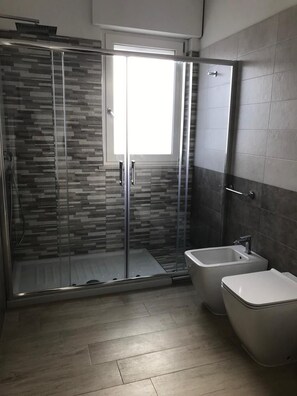 A modern bathroom with a glass-enclosed shower, a standalone bathtub, and a sink. - B&B Oleum (Terlizzi)