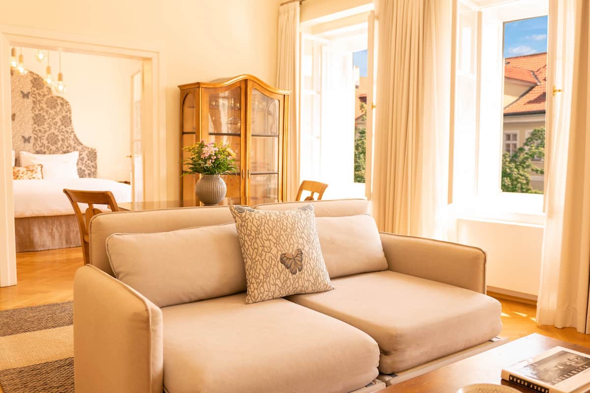 Una sala de estar con un sofá, un aparador de madera y una mesa de comedor.
