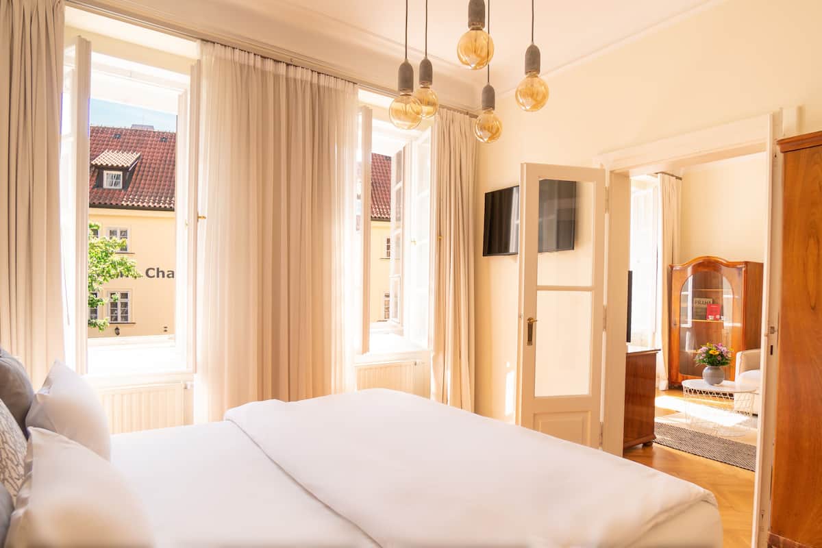 Un dormitorio con una cama grande, un televisor en la pared y vistas al exterior.