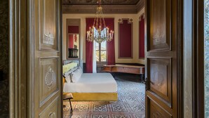 A room with a bed, a chandelier, and a piano. - Room of Andrea (Trapani)
