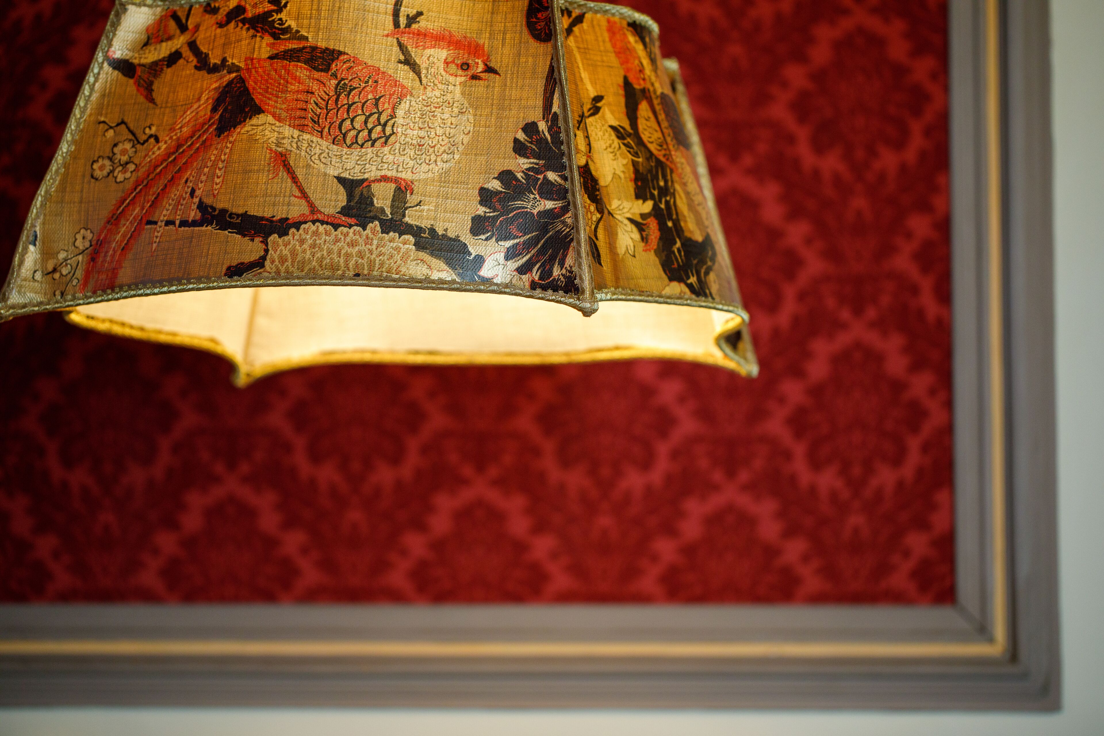 En lampe med fuglemotiv på skærmen.