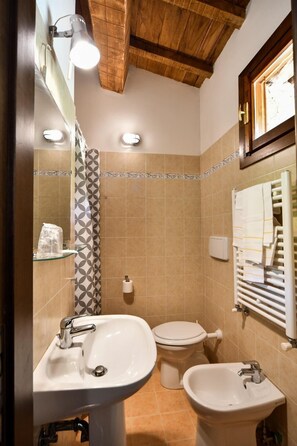 A bathroom with a sink, bidet, toilet, and a towel rack. - Agriturismo La Valle Dei Bronzetti (Cascia)
