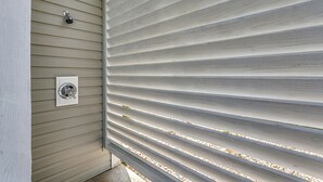 Ein Gebäudeteil mit horizontaler Fassadenverkleidung und einem Fenster mit Metallrahmen.