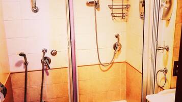 A bathroom with a toilet, a shower, and a sink.
