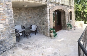 A stone building with a covered patio area featuring a table and chairs. - L'Antica Dimora (Macchiagodena)