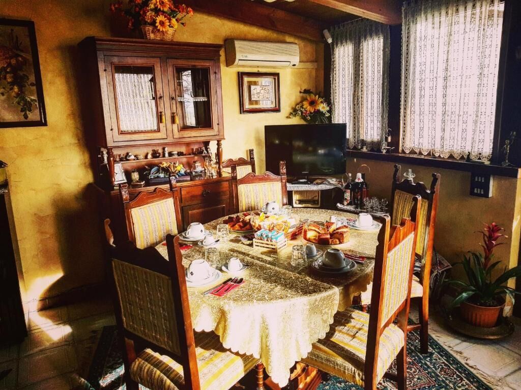 Un coin repas avec une table ronde dressée pour le repas, entourée de chaises en bois.