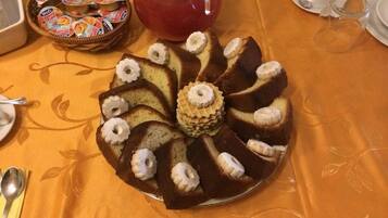 Ein Kuchen mit einem Ring aus Sahne und Bananenscheiben auf einem Teller.