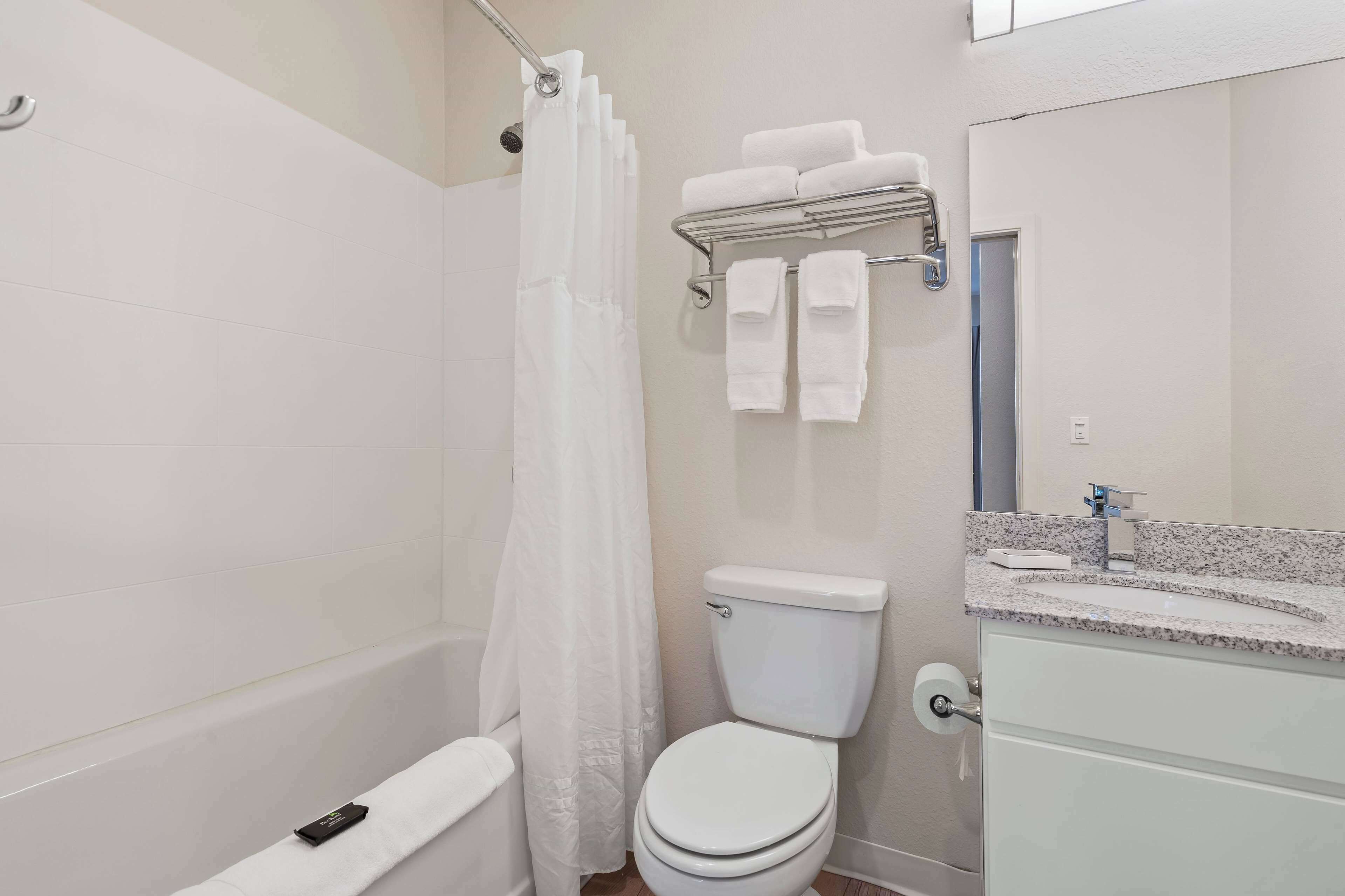 Une salle de bain avec douche, toilettes et lavabo.