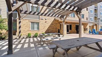 An outdoor patio area with picnic tables and a pergola structure.