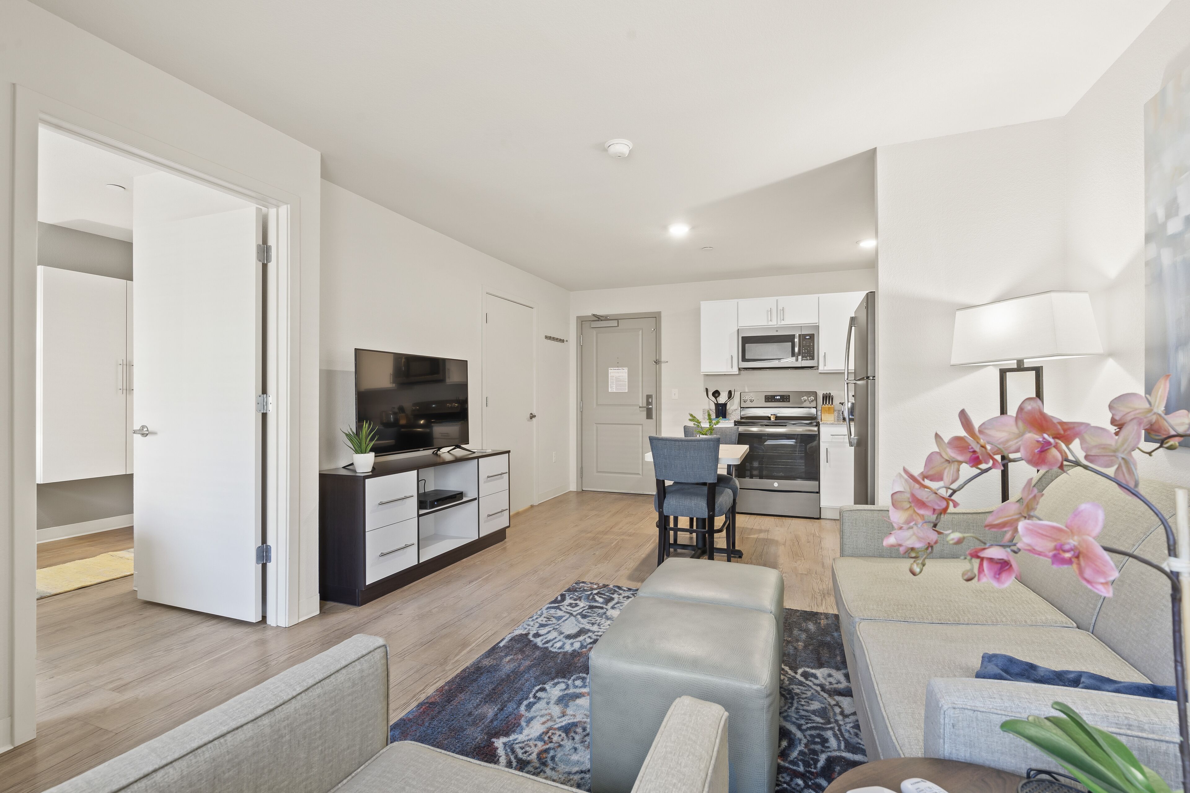 A modern apartment with a kitchen, dining area, and living room.