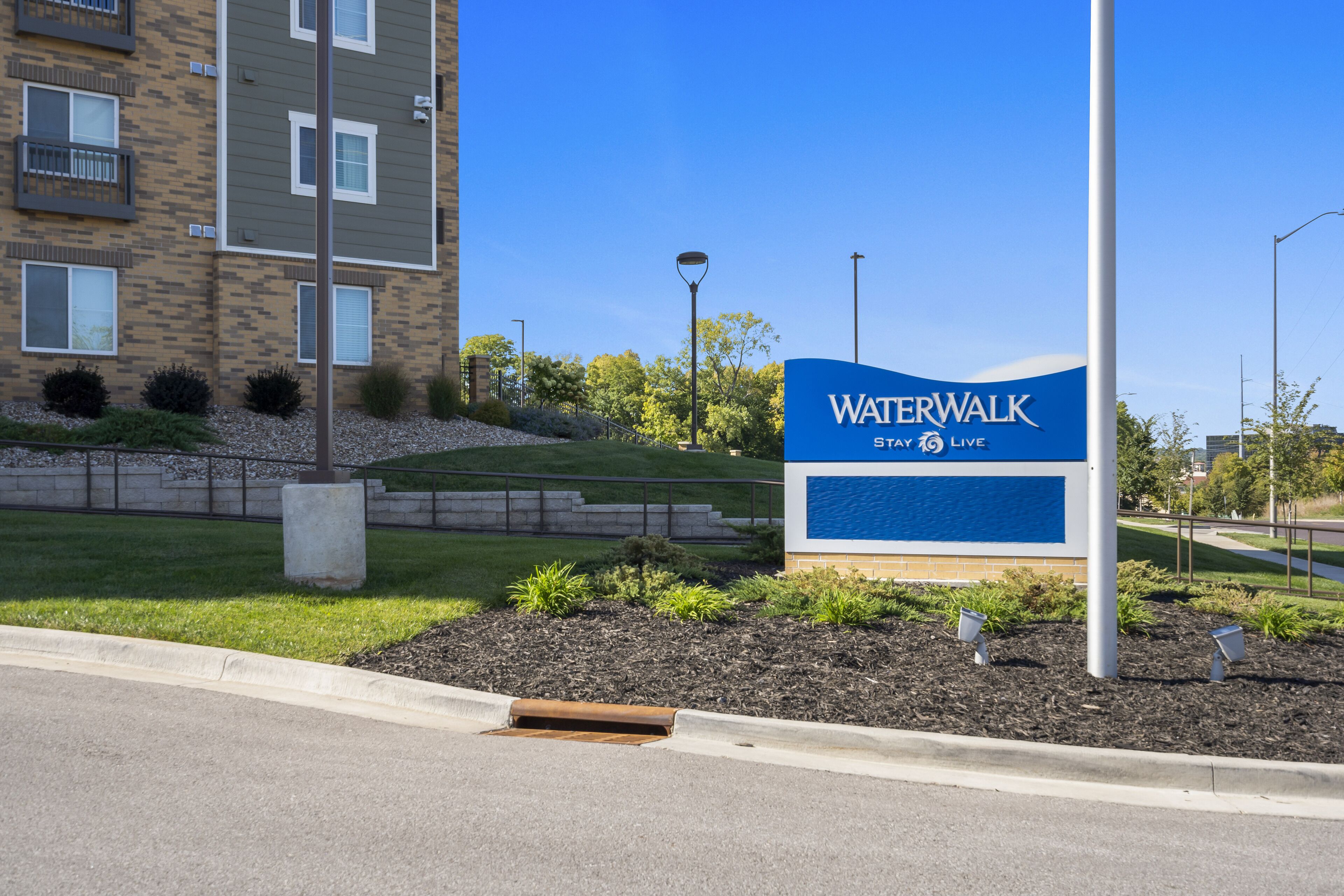 Un edificio con un letrero que dice "Waterwalk Stay to Live".