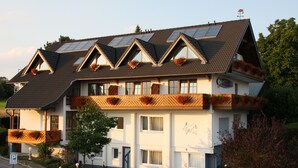 A two-story building with a sloped roof, multiple windows, and balconies with flower boxes. - Landhotel Napoleon (Wipperfuerth)