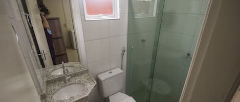 A bathroom with a sink, toilet, and glass shower enclosure.