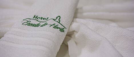 A white towel with embroidered text indicating a hotel name and location.