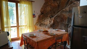 Un coin repas avec une table dressée pour quatre personnes, un réfrigérateur et un grand mur d’escalade.