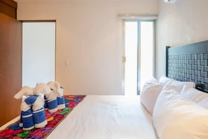 Une chambre d’hôtel avec un lit, un tapis coloré et une porte.