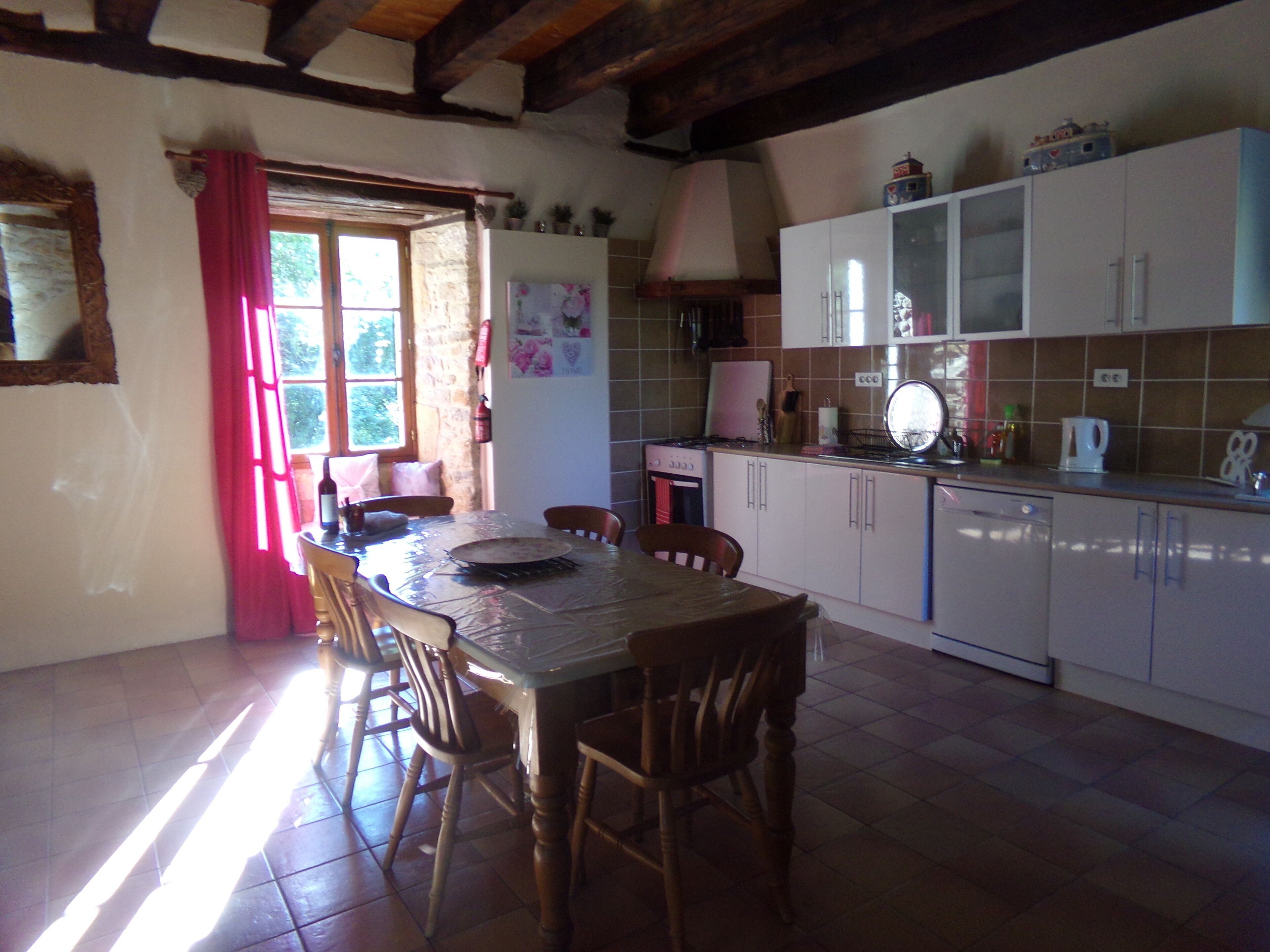 A kitchen with wooden chairs, a dining table, and cabinets.