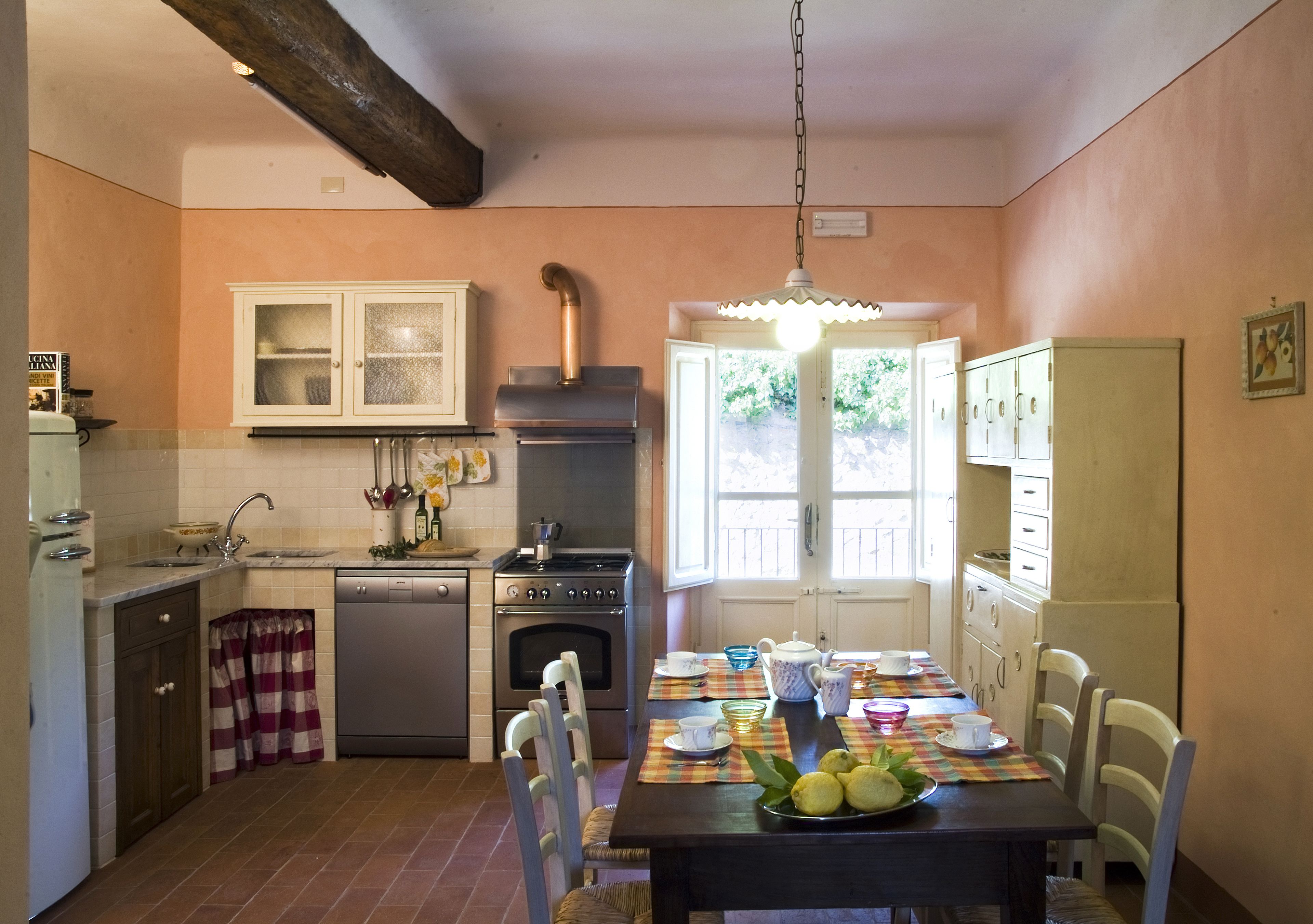 A kitchen with a dining table set for four, a stove, oven, and refrigerator.