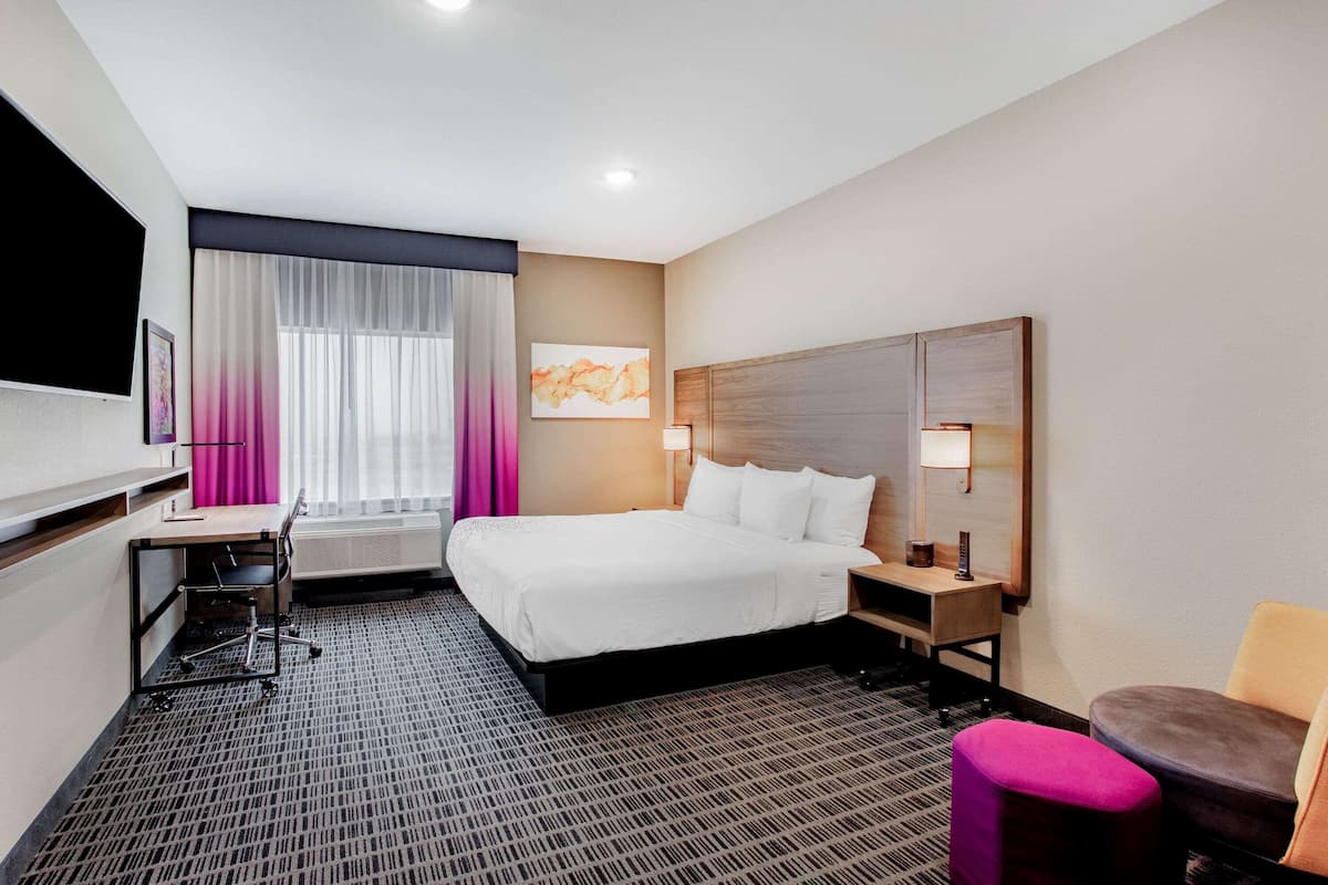 Une chambre d’hôtel équipée d’un lit, d’un bureau, d’une chaise et d’un téléviseur.
