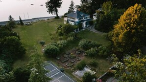 A large house with a well-maintained garden, a tennis court, and a view of the water. - Gorgeous location and getaway! Pickleball court! (Lakebay)