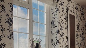 Una habitación con ventana, radiador y sofá.