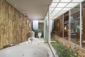 Een bad/douchecombinatie, een bubbelbad, een haardroger, handdoeken