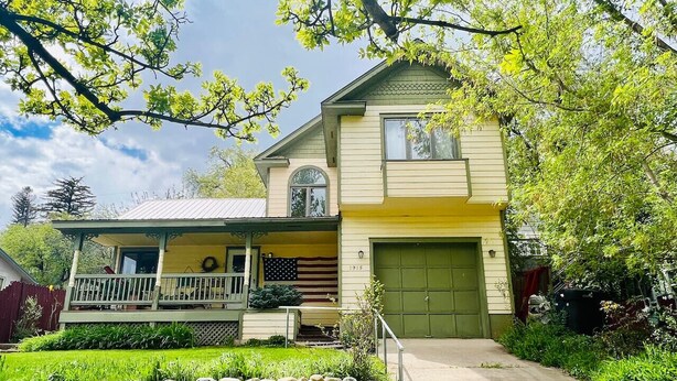 A two-story house with a porch, a garage, and a well-maintained lawn. - Garden Home: Private Home Downtown Durango (Durango)