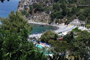 Um resort costeiro com piscina, praia e falésias rochosas.
