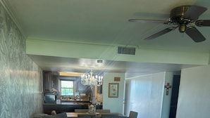 Una sala de estar moderna con un sofá modular, una mesa de centro de vidrio y una araña.