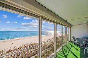 Un balcon avec vue sur une plage et l’océan.