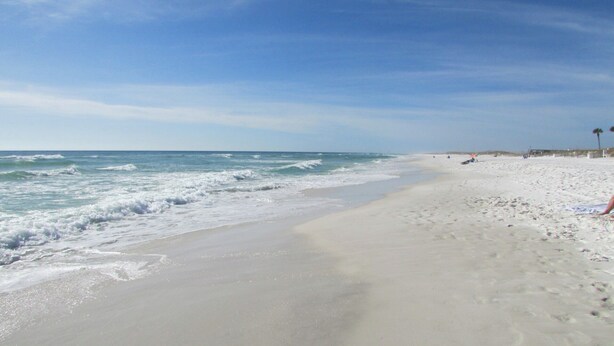 A beach with a sandy shore and waves.
