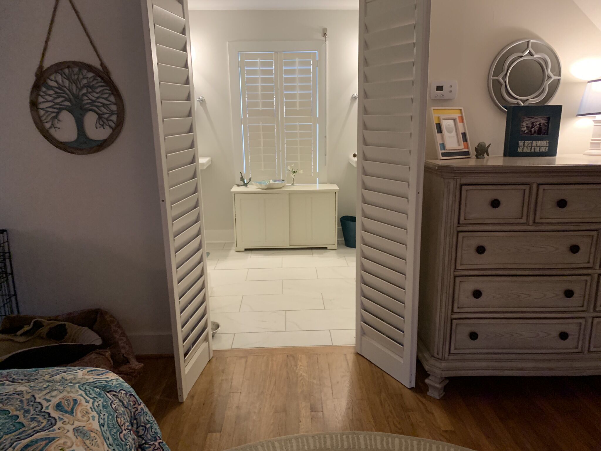 Une chambre à coucher comprenant un lit, une commode et une salle de bain avec une fenêtre et des toilettes.