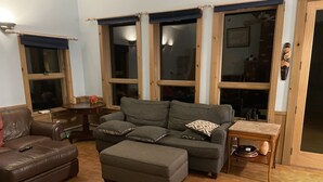 A living room with a grey sofa, a brown leather couch, and a wooden coffee table.