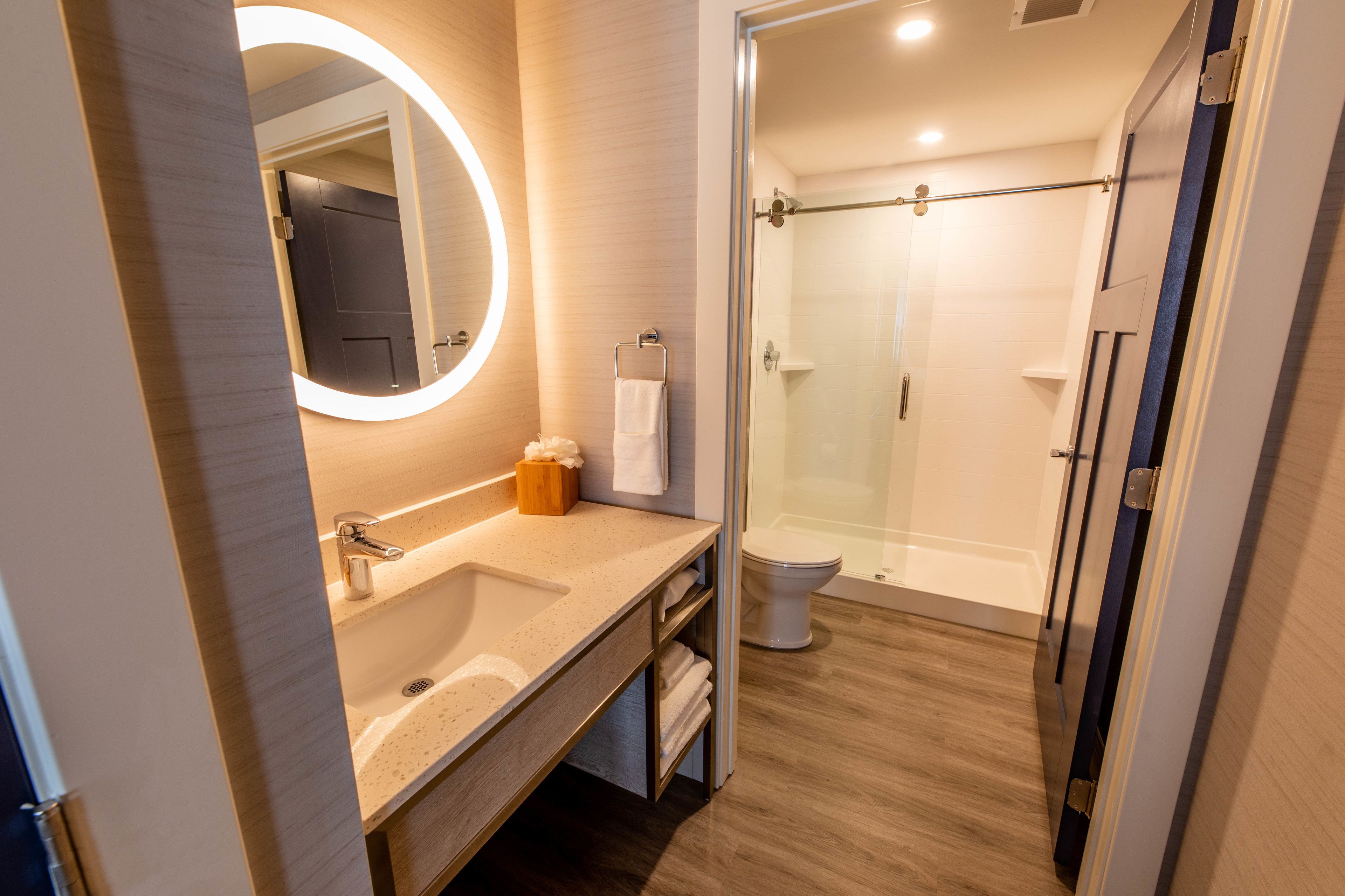 Une salle de bain moderne avec un lavabo, un miroir et une douche à parois de verre.