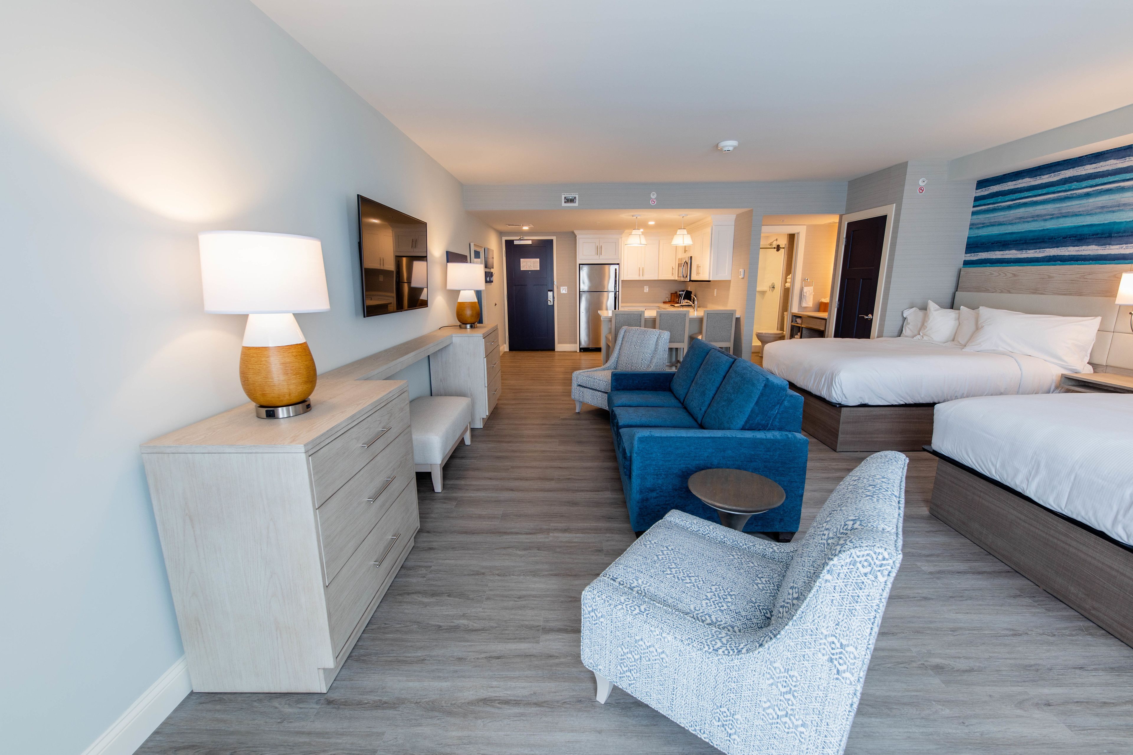 Una habitación de hotel moderna con cama, sofá, escritorio y zona de comedor.