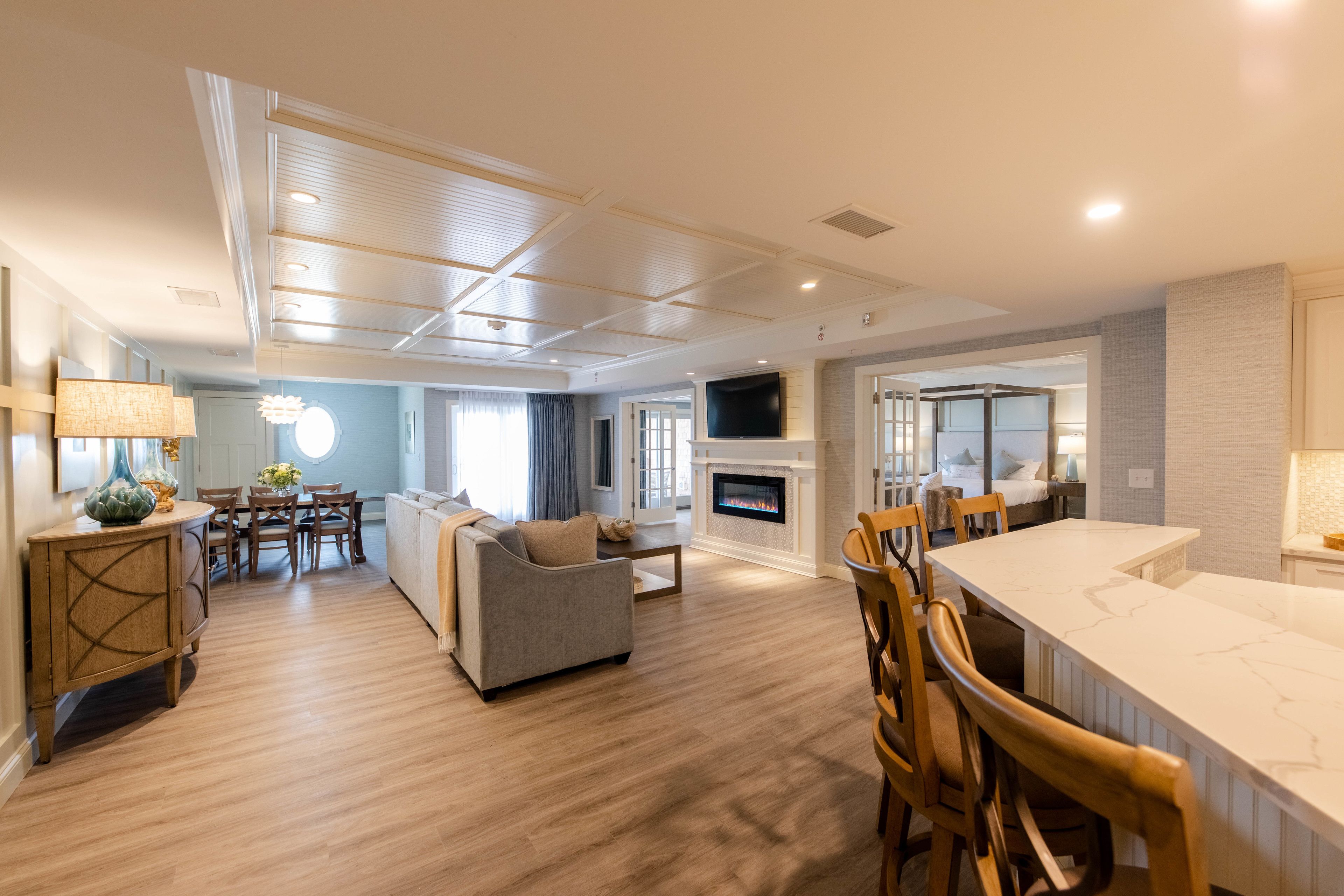 A spacious living area with a fireplace, a dining table, and a kitchen area with a large island.