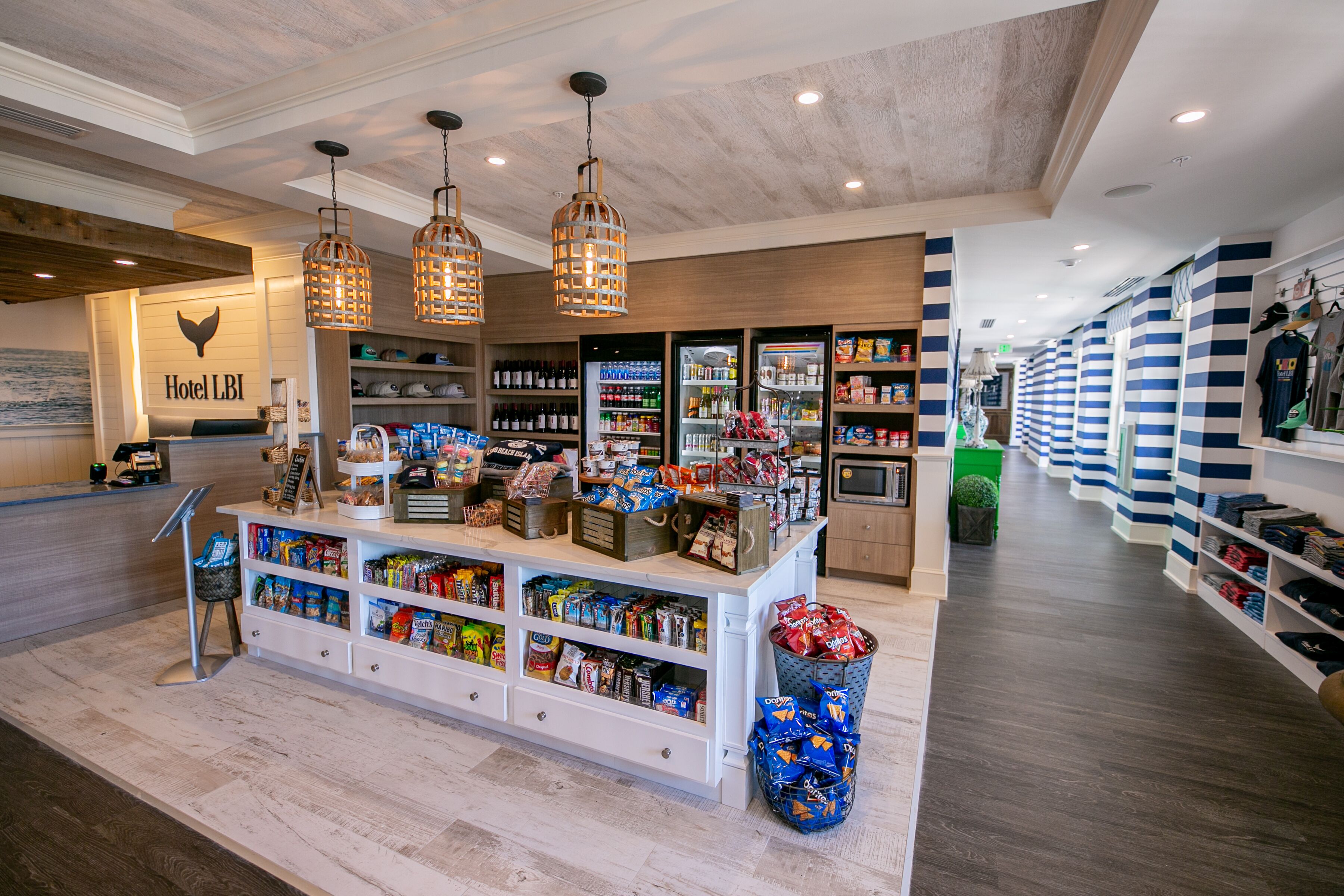 A hotel lobby with a reception desk, a snack bar, and a clothing store.
