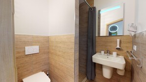 A modern bathroom with a shower, toilet, and sink.