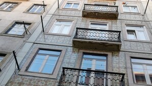 Un edificio de varios pisos con fachadas de baldosas decorativas, múltiples balcones y una variedad de estilos de ventanas.