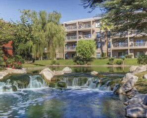 A hotel with a multi-story building, a landscaped garden, and a small waterfall. - 1 Bedroom Coachella Weekend Available (Indio)